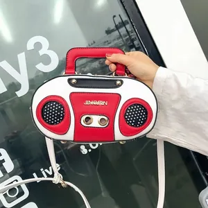 Detail of creative vintage radio shaped handbag with red handle and speaker accents