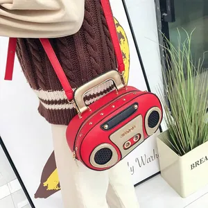Detail view of a red retro radio-style handbag with gold handle and metallic rivets