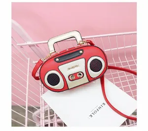 Close-up of vintage radio style handbag in red and gold finish with top handle