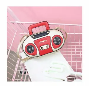 Detail of vintage radio-shaped handbag featuring contrast colors and gold chain strap