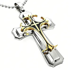 Gros plan d'un pendentif croix triple couche doré et argenté avec chaîne à billes