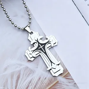 Détail du pendentif croix argenté avec gravure noire sur chaîne à billes et plumes