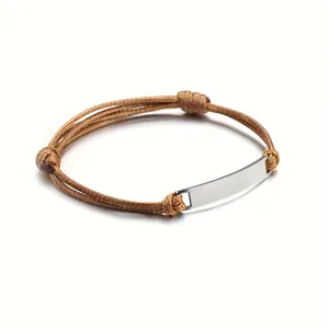 Close-up of adjustable brown braided wax rope bracelet with polished curved metal plate