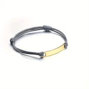Macro detail of mirror-polished gold metal plate on adjustable woven rope bracelet