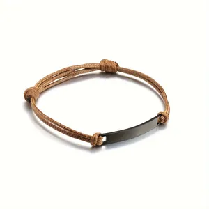 Detailed view of the matte black curved plate on a braided khaki cord bracelet for couples