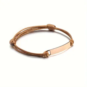Macro detail of polished rose gold plate on braided brown leather cord bracelet