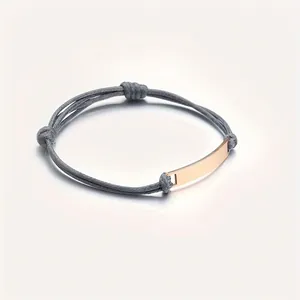 Detail view of woven wax rope bracelet with polished rose gold metal plate and sliding knots