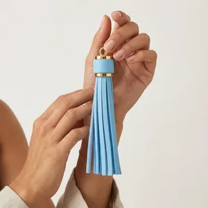 Close-up of light blue PU leather tassel pendant with dimensions 9cm by 1.5cm