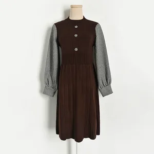 Elegant knit dress with houndstooth contrast sleeves and button detail on the neckline