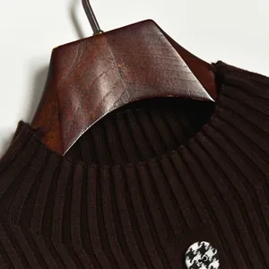 Brown ribbed knit dress with houndstooth button detail on a wooden hanger
