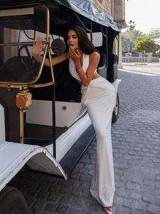 Détail de la robe licou blanche avec découpe à la taille et ourlet sirène élégant