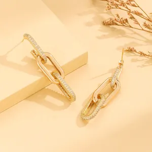 Detail view of gold interlocking chain earrings with sparkling rhinestone crystals