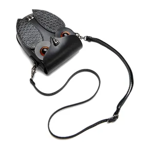 Détail du sac bandoulière hibou noir avec des yeux en cristal orange et textures d'écailles