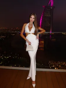 Robe longue blanche chic avec découpes, col licou et détails dorés en décor urbain luxe