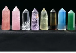 Macro detail of various polished natural crystal wands in a row on black surface