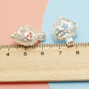 Detail view of heart-shaped hollow copper locket pendants with a ruler for size reference