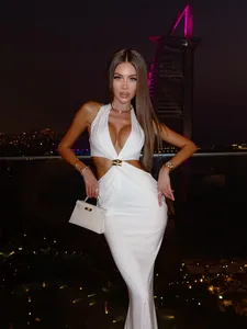 Détail de la robe maxi blanche à découpes avec boucle métallique et nœud design