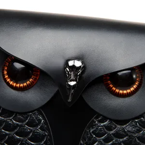 Gros plan détaillé d'un sac chouette avec boucle tête de mort et yeux ambrés brillants