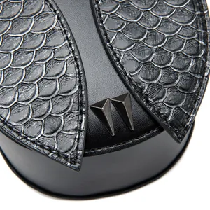 Gros plan sur la texture peau de serpent et rivets en métal du sac vintage noir en PU