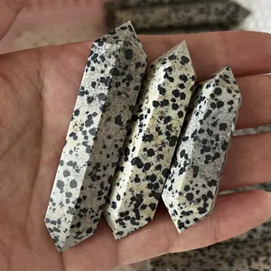 Primo piano di tre colonne di cristallo di diaspro dalmata lucidate tenute in mano
