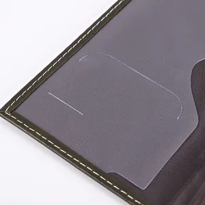 Close-up of the transparent window and white stitching on a PU leather passport cover