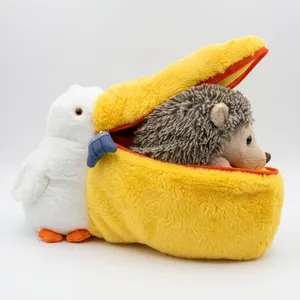 Macro detail of plush pelican storage pouch with a small hedgehog plush toy inside