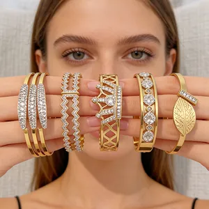 Golden stainless steel bangle set with crown, leaf, and geometric diamond designs