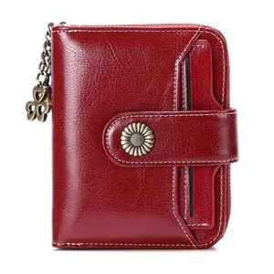 Detail of red leather wallet with vintage sunflower hardware and clover charm