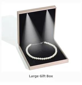 Macro shot of rose gold jewelry box with dual LED lights illuminating a pearl necklace