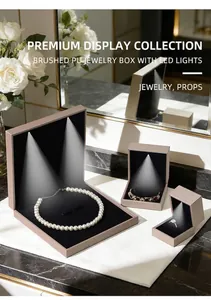 Detailed view of brushed PU jewelry box with LED light reflecting on pearl necklace