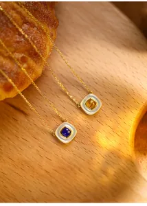 Detailansicht der quadratischen Lapis- und Bernsteinanhänger mit goldenen Ketten