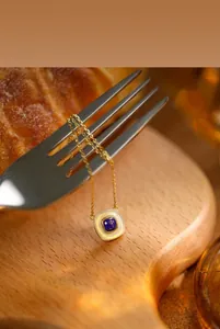 Detail von quadratischem Silberanhänger mit Lapislazuli und Perlmutt an goldener Kette