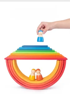 Nahaufnahme von 7-lagigen Regenbogen-Stapelsteinen aus Holz mit 3 passenden Holzfiguren