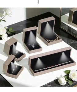 Close-up of champagne gold LED jewelry boxes with black velvet interior and spotlights