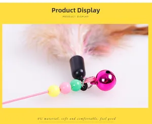 Detail of cat wand featuring pink metal bell, colorful beads and soft natural feathers
