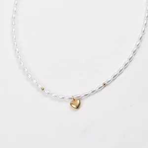 Close-up of pearl necklace with gold beads and heart pendant on 18k gold plated chain