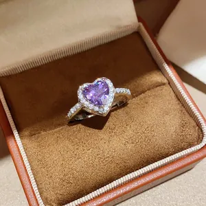 Detail of 18k gold plated heart ring with purple zircon in a brown velvet jewelry box