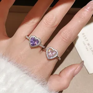 Close-up of 18k gold plated heart rings with purple and pink zircon stones on hand