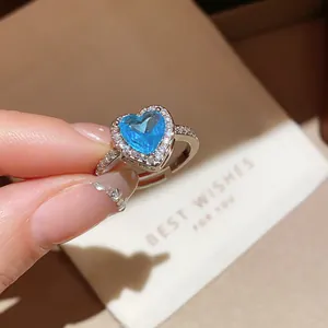 Detailed view of an 18k gold plated adjustable ring with a heart-shaped blue gemstone