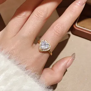 Close-up of 18k gold plated halo heart ring with zircon stones on a model's finger