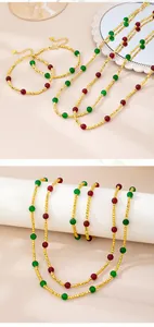 Detail of beaded gold jewelry set with red and green accents and heart pendant