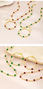 Close-up of gold beaded necklace and bracelet set with red and green gemstone accents