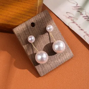 Macro detail of elegant double pearl drop earrings with fine gold chain and S925 silver pin