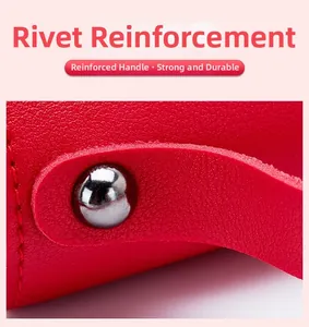 Detail view of red textured leather handbag showing durable rivet reinforcement on straps