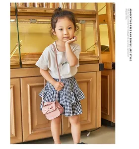Girl's pink mini leather crossbody bag with bow decoration worn by a child model