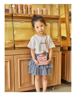 Detail view of pink mini bow crossbody bag for girls styled with casual summer outfit