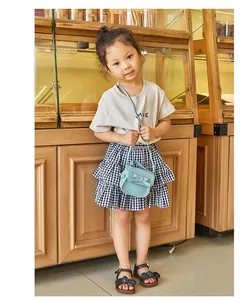 Close-up of light blue mini crossbody bag with a delicate bow on a child model