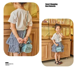 Detail showing a light blue mini crossbody bag with a bow on a child model