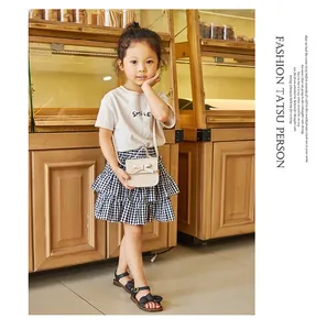 Close-up of a girl's mini shoulder bag with bow and summer smile tee in a cafe setting