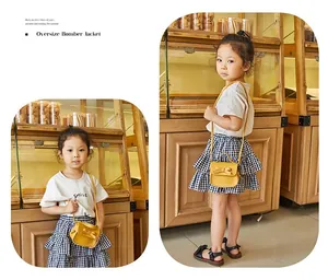 Mini yellow shoulder bag with bow detail worn by a child girl in a cozy bakery shop